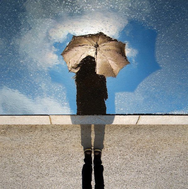 web design marketing seo | A female looking at the reflection of her umbrella, considering how it could help in design