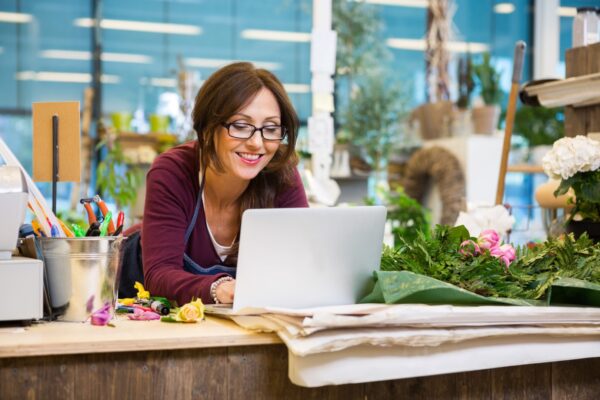 Florist using laptop to create social media content